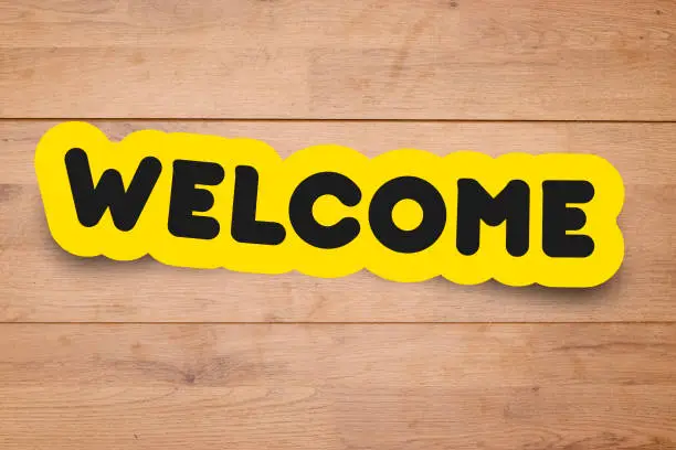 word welcome on wooden table