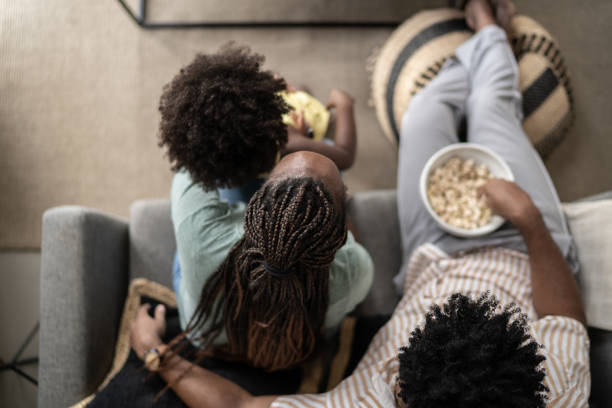 high angle view of family eating popcorn and watching tv at home - apartment television family couple imagens e fotografias de stock