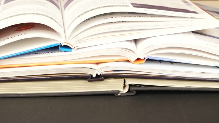 Open books in different bindings  on a dark table