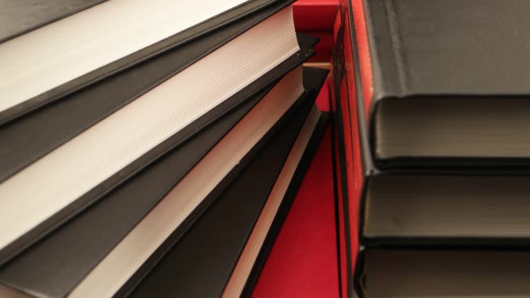 Books in red and black bindings on a dark table