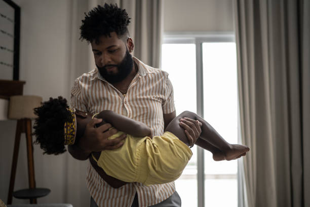 istock Father carrying sleeping daughter at home 1309450260