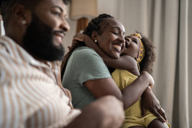 ragazza carina che abbraccia la madre a casa - couple black american culture african culture foto e immagini stock