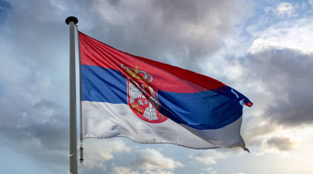 istock Serbia flag waving against cloudy sky 1309457000