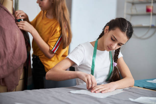istock Charming female kids working in sewing workshop 1309458081