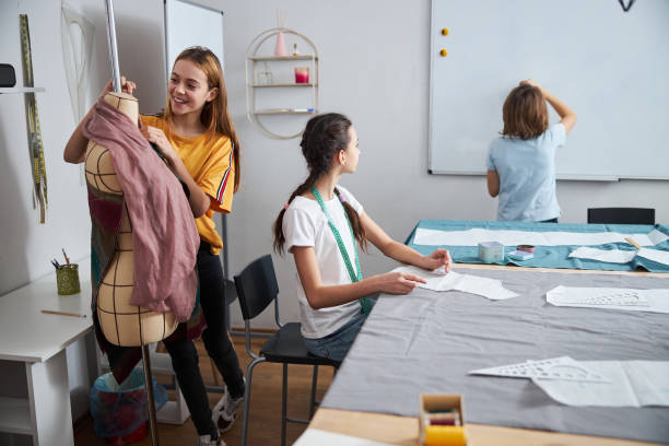 istock Adorable female kids working in sewing workshop 1309458086