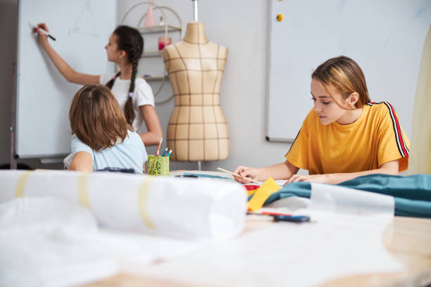 istock Adorable female children working in sewing workshop 1309458144