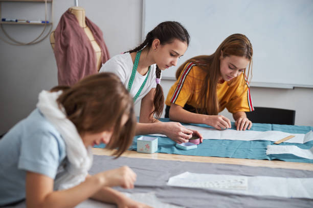 istock Charming little seamstresses working in sewing workshop 1309458169