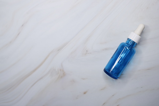 Blue perfume bottle with a sprayer on white