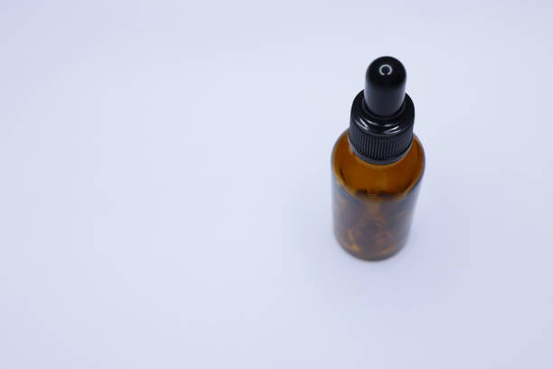 piccola bottiglia a goccia marrone vuota su sfondo bianco, contagocce in vetro utilizzato nell'industria cosmetica e farmaceutica - herbal medicine flash foto e immagini stock