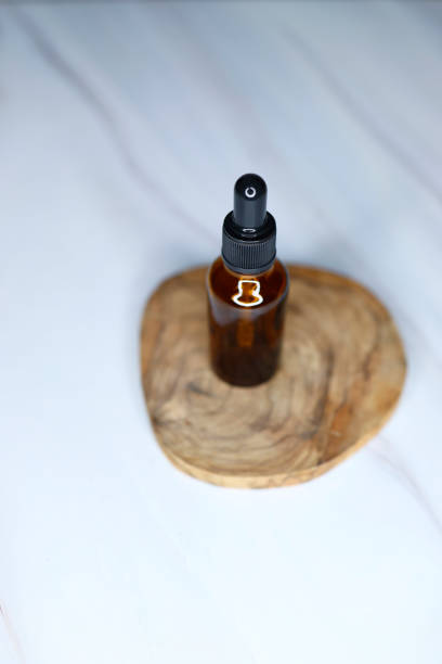 istock Empty small brown drip bottle on a white-gray marble background, Glass dropper used in the cosmetics and pharmaceutical industry 1309460438