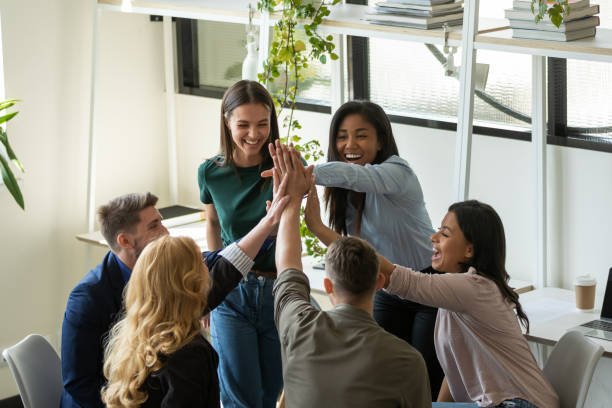 istock Excited business team join palms in high five feeling happy 1309460463