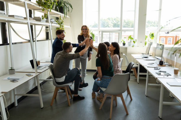 istock Multiethnic staff and woman trainer stacking hands in high five 1309460466