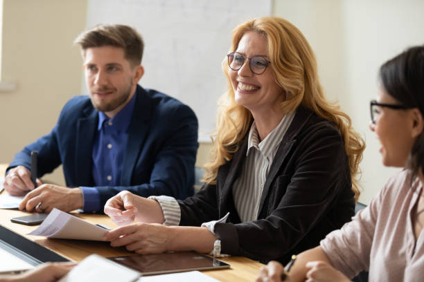 istock Experienced senior female coach teaching diverse interns at conference table 1309460511