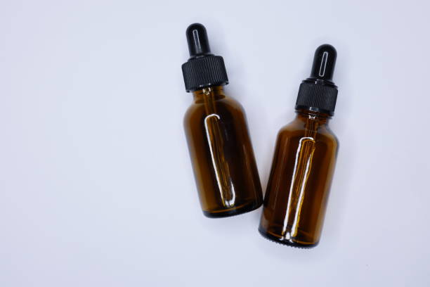 istock Two empty small brown drip bottles on a white background, Glass dropper used in the cosmetics and pharmaceutical industry, Close-up 1309462837