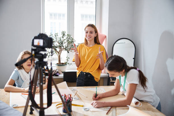 istock Cheerful girls recording video in sewing workshop 1309464731