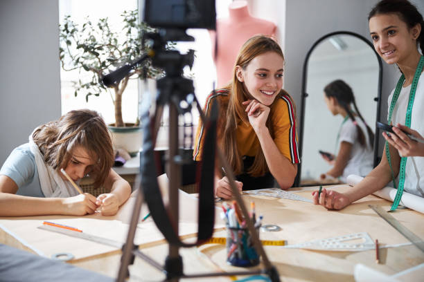 istock Cheerful cute girls recording video in sewing workshop 1309464741