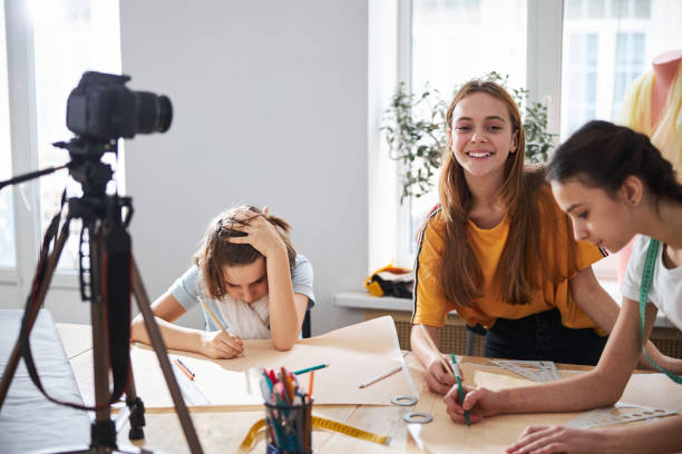 istock Cheerful kids recording video for sewing blog in workshop 1309464744