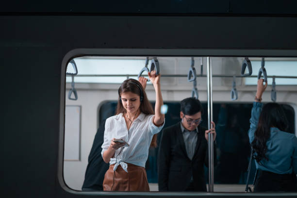 the woman was using the phone on public transport while the man standing next to fall asleep with exhaustion after work - 3109 imagens e fotografias de stock