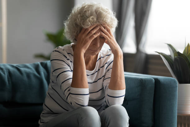 不健康な老年上の退職した女性は強い頭痛に苦しんでいます。 - old senior adult women tired ストックフォトと画像