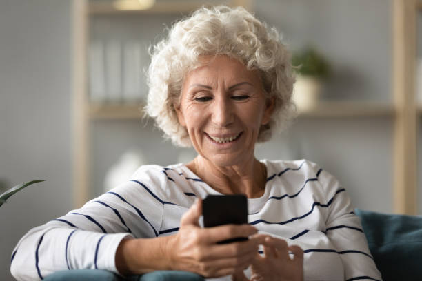 istock Happy old senior grey-haired woman using mobile applications. 1309468418