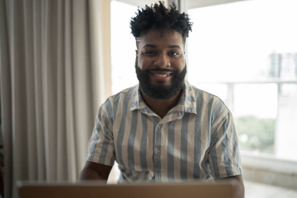 istock Portrait of a young man using laptop at home 1309469121