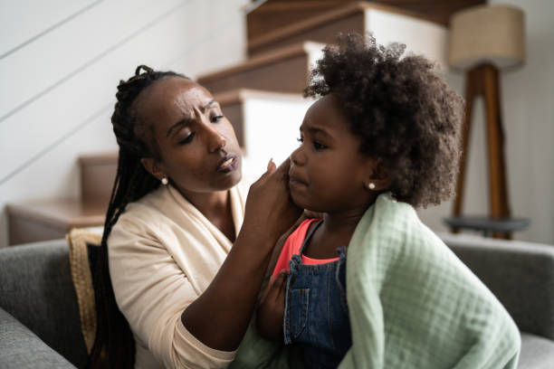 istock Mother is checking her daughter's temperature at home 1309469158