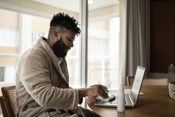 istock Young man cleaning laptop at home 1309469202