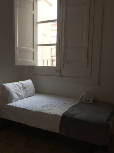 istock Photo of a bed under a window in a hotel 1309470075