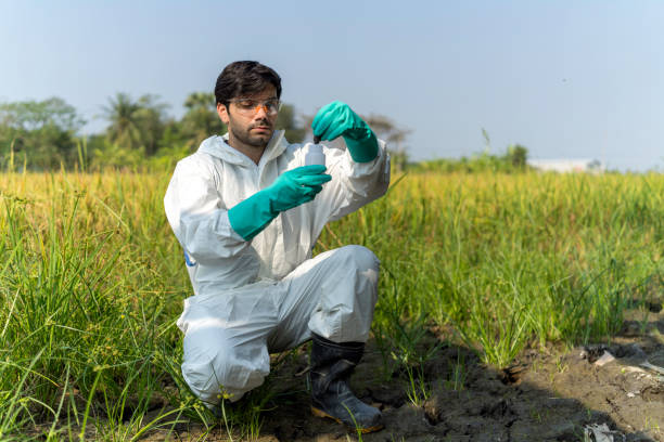 A man in full body protective suit collecting samples of soil A technician in overall protective suit collecting samples of soil potentially contaminated by toxic material ,Portable multi parameter water quality measurement ,water quality monitoring concept ,ph checking on field. soil tester stock pictures, royalty-free photos & images