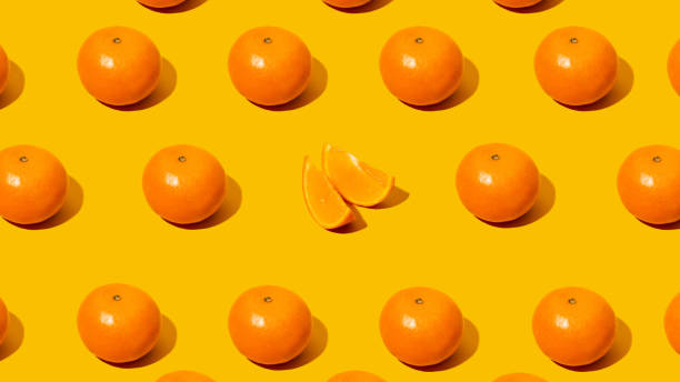 istock Fresh citrus Seamles fine pattern. Ripe fruit tangerines. Trendy sunlight Summer,spring pattern made with mandarine slice on bright light orange background. Minimal summer concept. MonochromaticBanner 1309471225