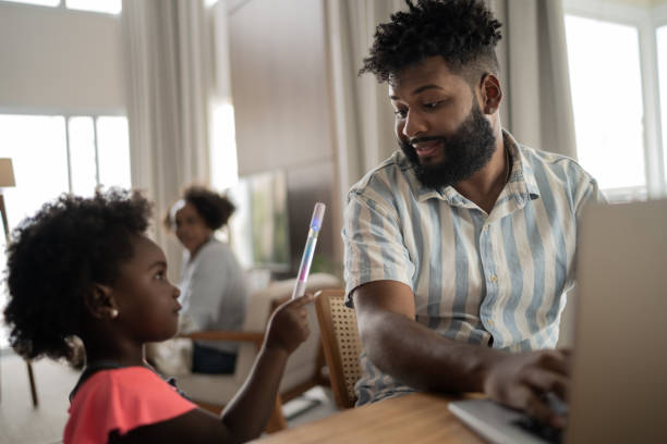 istock Man working while his daughter arrived at home 1309471770