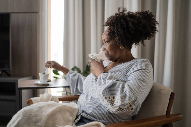 istock Mature woman using an inhalation mask at home 1309471795
