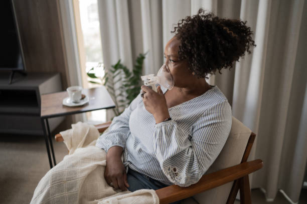 istock Mature woman using an inhalation mask at home 1309471798