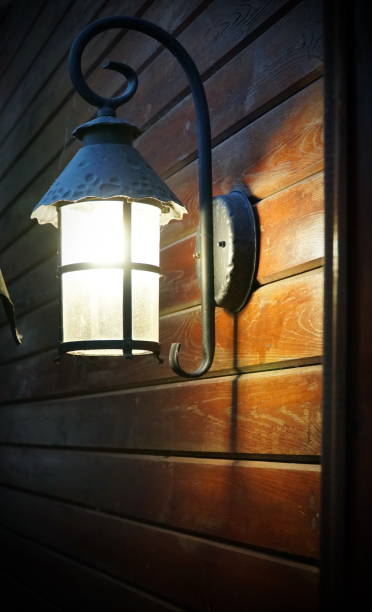istock Classic lamp on a wooden wall, vintage filtered image. 1309475238