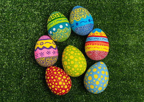 Colorful hand painted Easter eggs on green grass background. Easter decoration