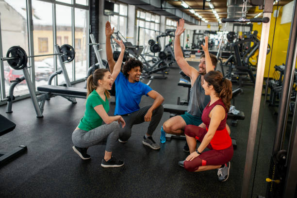 istock Happy athletes joining hands in unity in a gym 1309482596