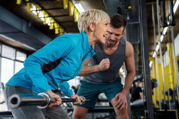 istock Personal trainer working exercise with senior woman in the gym 1309484323