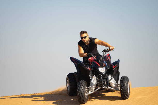 istock Muscular Man Riding Atv In the Desert 1309486568
