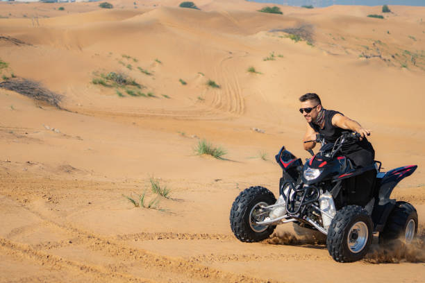 istock Muscular Man Riding Atv In the Desert 1309486623