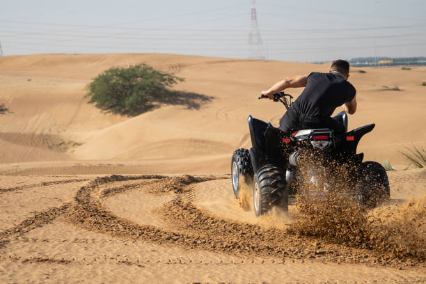istock Muscular Man Riding Atv In the Desert 1309486678