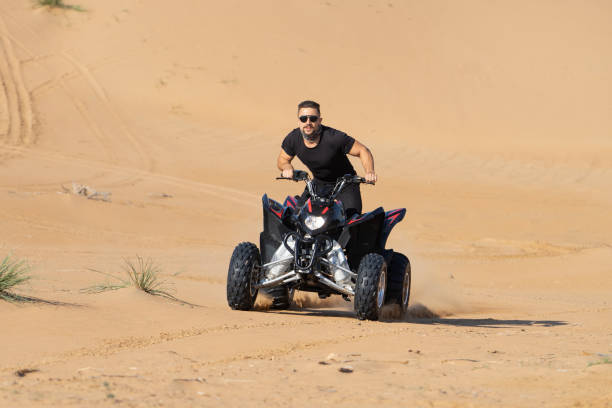 istock Muscular Man Riding Atv In the Desert 1309487250