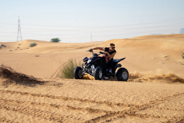 istock Muscular Man Riding Atv In the Desert 1309487345