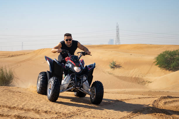 istock Muscular Man Riding Atv In the Desert 1309487393