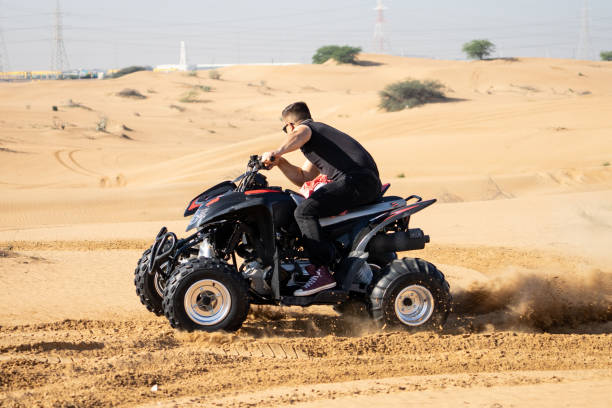 istock Muscular Man Riding Atv In the Desert 1309487521