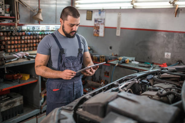 istock Car mechanic using tablet while repairing broken vehicle in auto repair shop 1309488213