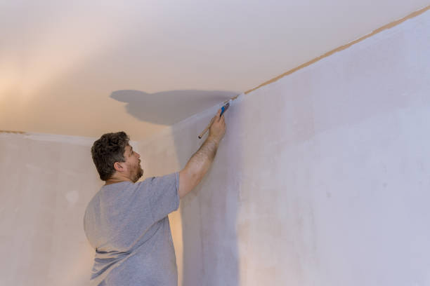 istock Painter hands with painting the wall the corners edge with brush 1309489365