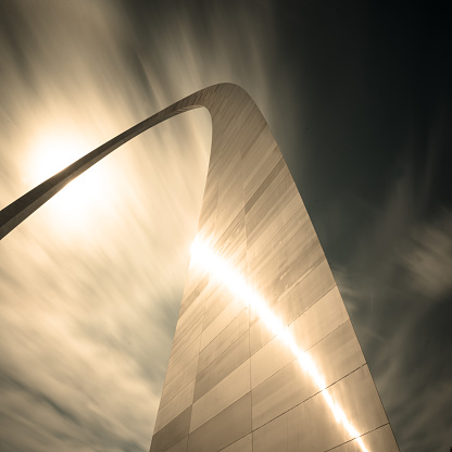 The St Louis arch in Missouri is the most significant landmark in the city. The sun hides behind the arch top creating a striking reflection on the side of the building
