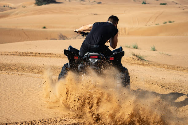 istock Muscular Man Riding Atv In the Desert 1309492665