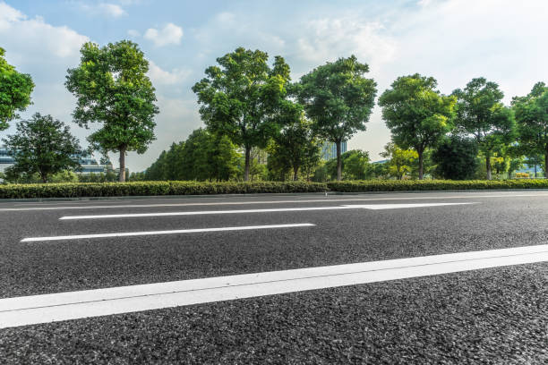 istock Asphalt road and green trees under blue sky 1309498034