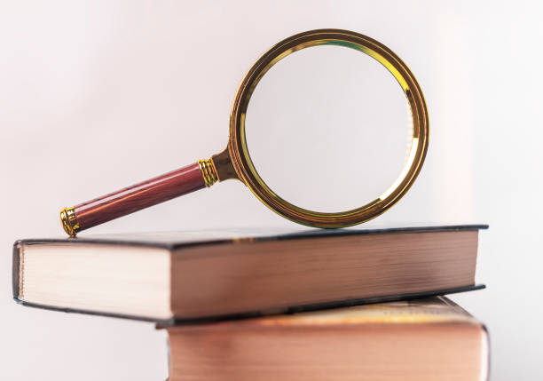 istock Education and research concept. Magnify glass on books 1309498783